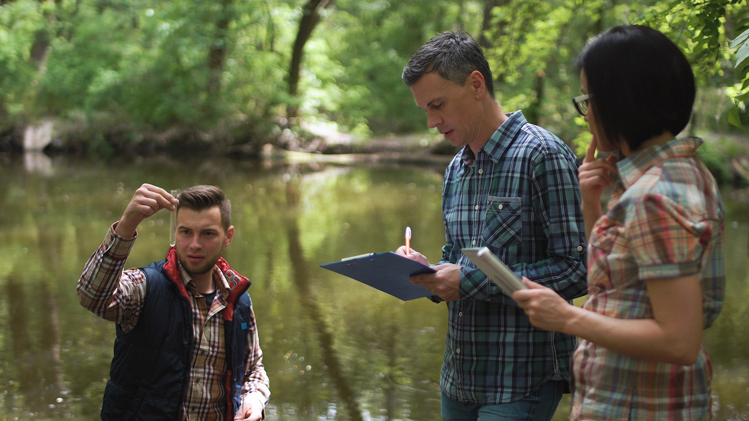 Three scientists taking a water sample