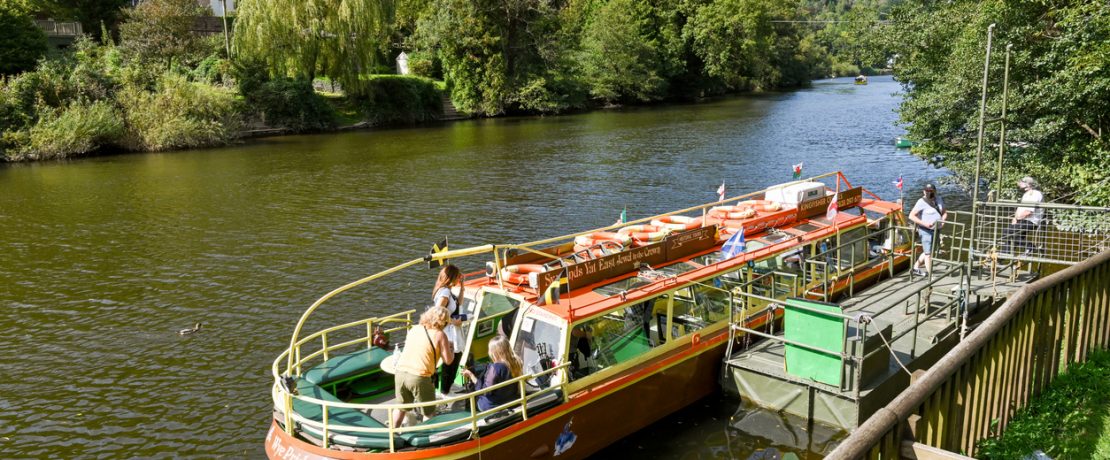 People getting off a small boat after a trip on the River Wye