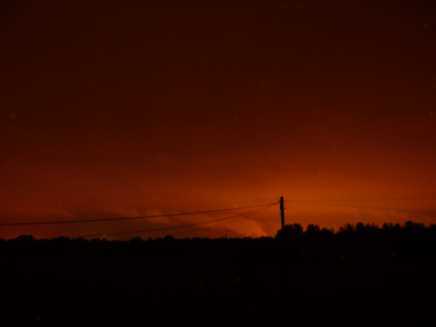 Glow from a distant town colouring the night sky orange-red