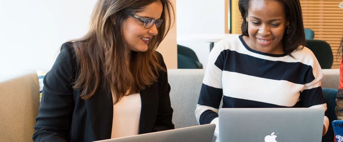 Two planning volunteers working together on laptops