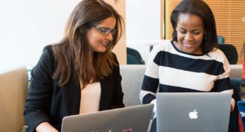 Two planning volunteers working together on laptops