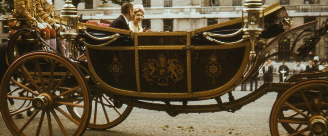 The young Queen in 1965 sitting in an open horse-drawn carriage with Prince Philip