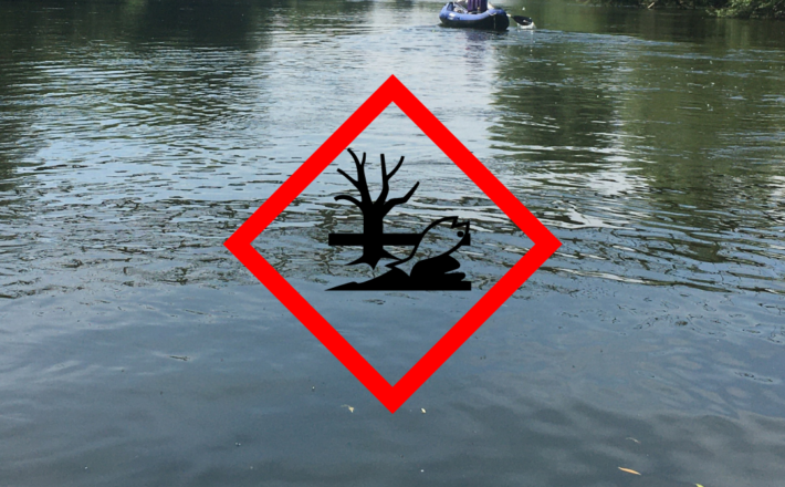Photo of the River Wye with a pollutant sign in front